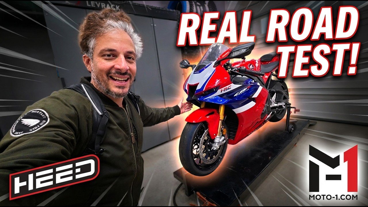 Adam Waheed points to a red, white and blue 2026 Honda CBR1000RR-R Fireblade SP on a garage lift in Moto-1 Real Road Test thumbnail art