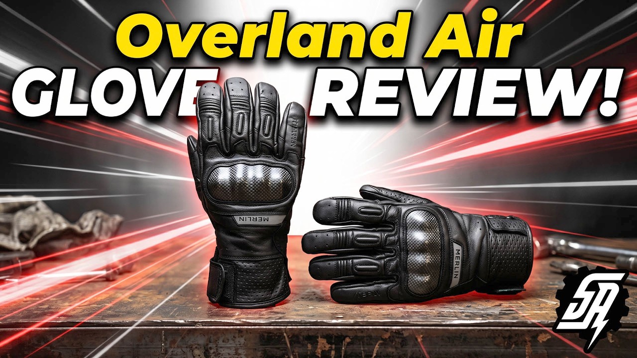 Pair of black Merlin Overland Air perforated leather motorcycle gloves with carbon fiber knuckle armor on a workbench